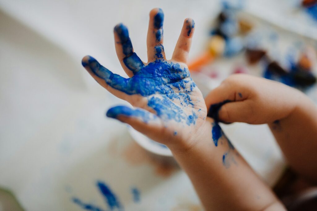 person with blue paint on hand